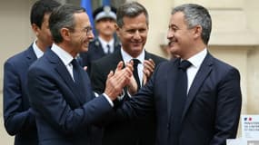 Le nouveau ministre de l'Intérieur Bruno Retailleau (gauche) applaudit  Gérald Darmanin lors de la passation de pouvoir à l'hôtel de Beauvau le 23 septembre 2024 à Paris