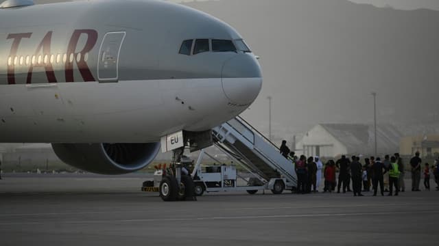 Des passagers montent à bord d'un avion de la Qatar Airways, le 10 septembre 2021 à l'aéroport de Kaboul, en Afghanistan
