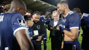 Les joueurs du Paris FC entourant le président du club Pierre Ferracci en attendant la validation de la montée en Ligue 1, 2 mai 2025