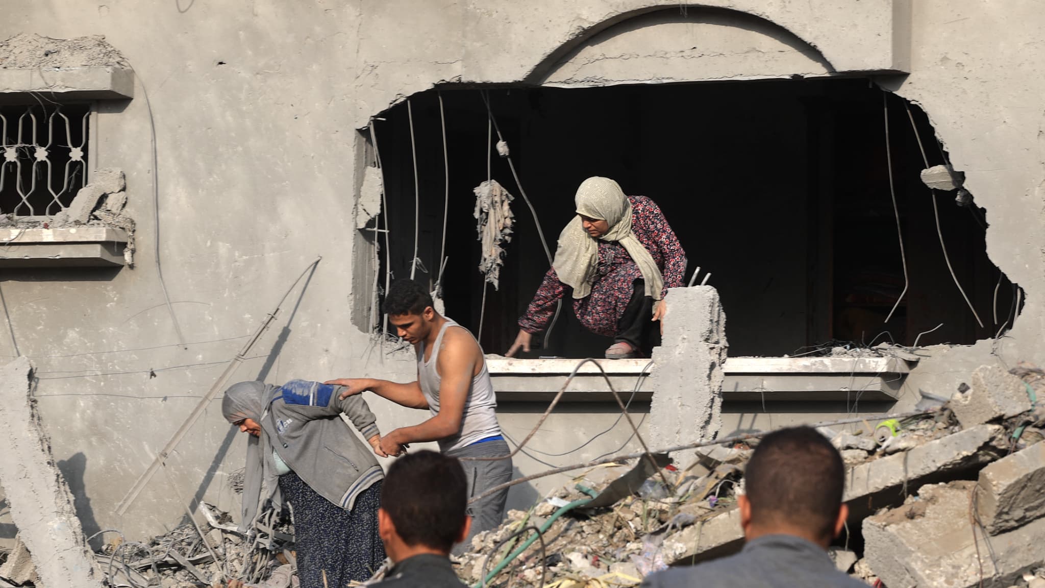 Un Palestinien aide à évacuer une femme à sortir d'un bâtiment détruit après les frappes israéliennes de la nuit sur Rafah, dans le sud de la bande de Gaza, le 22 octobre 2023. Un Palestinien aide à évacuer une femme à sortir d'un bâtiment détruit après les frappes israéliennes de la nuit sur Rafah, dans le sud de la bande de Gaza, le 22 octobre 2023.