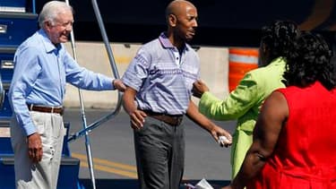 Aijalon Mahli Gomes (au centre), un Américain emprisonné pour avoir pénétré en territoire nord-coréen, retrouve ses proches à l'aéroport de Boston sous les yeux de l'ancien président Jimmy Carter (à gauche), qui a obtenu sa libération. Cet enseignant avai