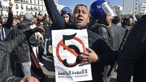 Un manifestant brandit une pancarte avec un "5" barré et une inscription "Non au 5e mandat" d'Abdelaziz Bouteflika, le 22 février 2019 à Alger. 