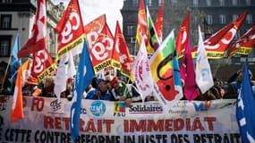 Mobilisation contre la réforme des retraites de manifestants brandissant des drapeaux de syndicats, le 28 mars 2023 à Clermont-Ferrand