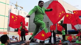Chen Guangbiao, avec costume vert pomme et drapeaux rouges, un excentrique modèle d'écologie à la chinoise.
