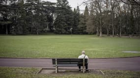 Un homme assis sur un banc du Parc de la Tête d'Or à Lyon.