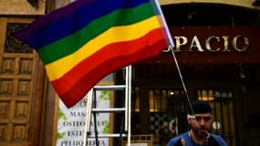 Un homme accroche un drapeau arc-en-ciel dans le quartier de Chueca, le 23 juin 2017 à Madrid