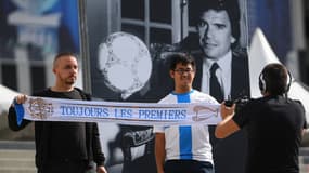 Des supporters posent devant le portrait de Bernard Tapie installé devant le stade Vélodrome le 3 octobre 2021