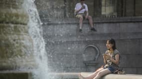 Une femme se rafraîchit à Trafalgar Square, dans le centre de Londres, le 18 juillet 2022. 