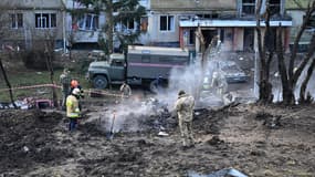 Des militaires ukrainiens inspectent les restes d'un missile dans la cour d'un bâtiment endommagé après une attaque au missile à Lviv, dans l'ouest de l'Ukraine, le 29 décembre 2023, dans le cadre de l'invasion russe de l'Ukraine.