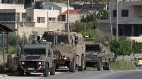 Des véhicules de l'armée israélienne stationnés à l'entrée du  camp de réfugiés palestiniens de Nour Chams, près de la ville de Tulkarem, dans le nord de la Cisjordanie, le 10 avril 2022