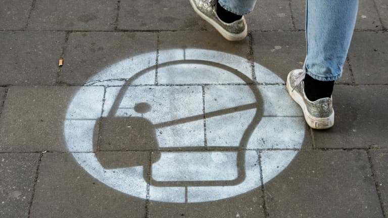 Un marquage au sol sur un trottoire appelle au port du masque à Berlin le 10 mars 2021
