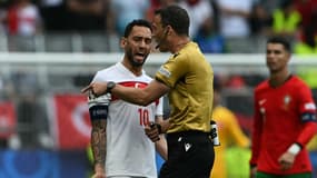 Le Turc Hakan Calhanoglu râle auprès d'un arbitre pendant l'Euro, le 22 juin 2024