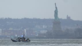 Un bateau de sauvetage de la police de New York est visible près de la Statue de la Liberté à New York après le crash d'un hélicoptère dans l'Hudson, le 10 avril 2025.