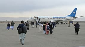 Des passagers embarquent à bord d'un avion de la compagnie Ariana Afghan Airlines à destination de Kaboul le 5 février 2022 à Hérat 