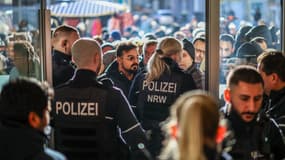 Des policiers et des clients inquiets se tiennent devant une agence de la banque Sparkasse à Gelsenkirchen, dans l'ouest de l'Allemagne, le 30 décembre 2025, après le braquage de la banque.