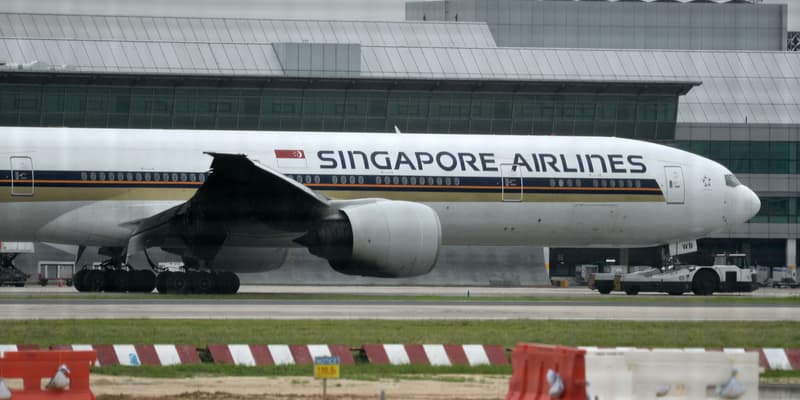 Un Boeing 777-300ER de Singapore Airlines, dont l'aile tribord a été carbonisée par un incendie de moteur lors d'un atterrissage d'urgence, est remorqué sur le tarmac de l'aéroport international de Changi, à Singapour, le 27 juin 2016.