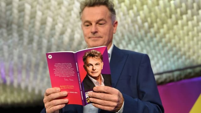 Le candidat du parti communiste à la présidentielle Fabien Roussel avec son livre-programme à Paris le 24 janvier 2022.