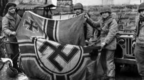 Des soldats anglais tenant un drapeau nazi au moment de la libération (photo d'illustration)