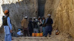 Des Afghans en train d'essayer de sauver le petit garçon coincé dans un puits dans le sud-est du pays.