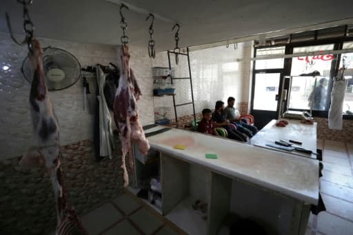 Des Syriens attendent des clients, dans une boucherie vide à Bennich, dans le nord-ouest de la région d'Idleb, en Syrie, le 9 juin 2020 Des Syriens attendent des clients, dans une boucherie vide à Bennich, dans le nord-ouest de la région d'Idleb, en Syrie, le 9 juin 2020