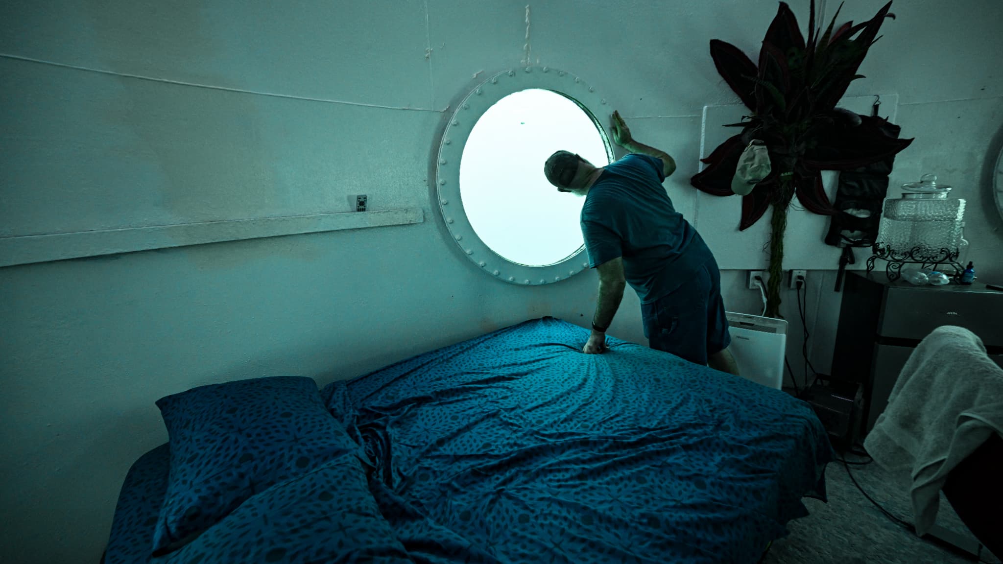 Rudiger Koch, dans sa capsule immergée, regarde au travers du hublot. Derrière la vitre, une lumière turquoise diffuse. Le 26 novembre 2024.