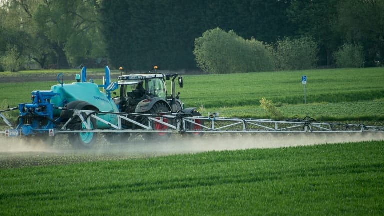 Un tracteur répand des pesticides sur un champ (image d'illustration)