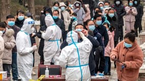 Des habitants attendent pour faire un test de dépistage du Covid-19, le 26 janvier 2022 à Anyang, en Chine