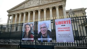 Les portraits de Cécile Kohler (G) et de Jacques Paris (C) exposés sur les grilles du Palais Bourbon, siège de l'Assemblée nationale française à Paris, le 25 mars 2025