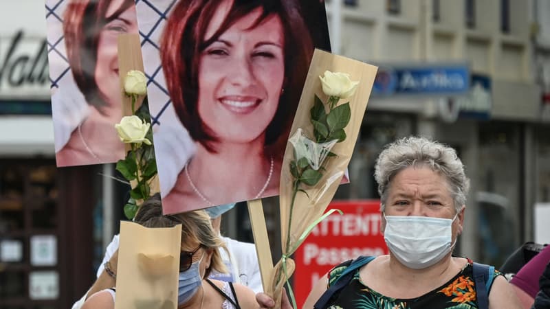 Des femmes brandissent des fleurs et des portraits lors d'une marche silencieuse à Douai, dans le nord de la France, le 12 juin 2021, en mémoire d'Aurélie Langelin, décédée le 31 mai. Le compagnon d'Aurélie Langelin a été placé en garde à vue le 1er juin 2021.
