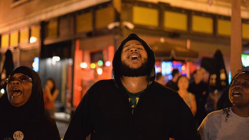 Des habitants chantent lors d'une manifestation pour protester contre le meurtre d'une jeune noir américain à Saint-Louis