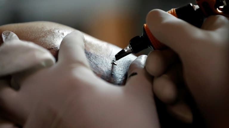 Une personne effectuant un tatouage. (Illustration)