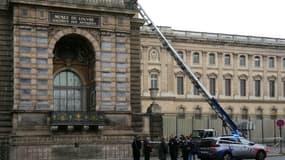 Des policiers français se tiennent à côté du monte-charge utilisé par des cambrioleurs pour pénétrer dans le musée du Louvre, sur le quai François Mitterrand, à Paris, le 19 octobre 2025