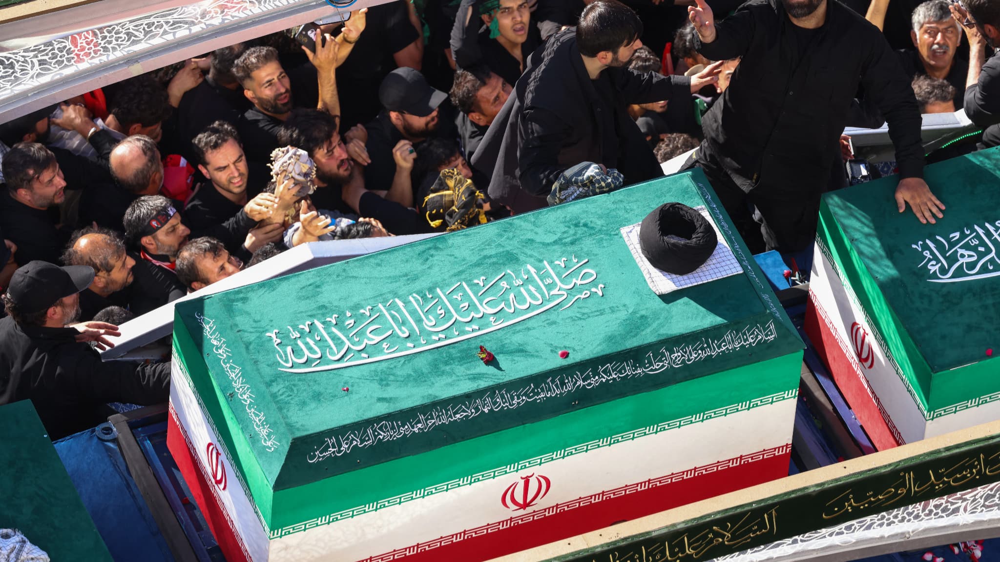 Une foule en deuil entoure le convoi transportant les cercueils du guide suprême iranien assassiné et des membres de sa famille lors d'une procession funéraire à Mashhad, le 9 juillet 2026.