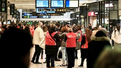 Des employés de la SNCF viennent en aide à des passagers en gare Montparnasse lors d'une grève des contrôleurs de la SNCF, à Paris le 2 décembre 2022
