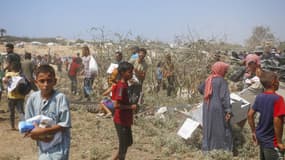 Des Palestiniens récupérant de l'aide humanitaire distribuée par parachute à l'ouest de Deir al-Balah, au centre de Gaza, le 28 juillet 2025.