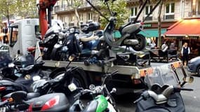 Enlèvement de deux-roues pour stationnement gênant, à Paris. Les auteurs d'infractions légères au code de la route seront aussi mis à contribution pour boucler le budget 2011 de la France, marqué par la lutte contre les déficits qui grèvent les caisses de