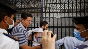 L'accusé du meurtre d'une étudiante Naira Ashraf entouré de gardes alors qu'il sort du box des accusés, après sa première séance de procès au palais de justice de Mansoura, à quelque 145 km au nord de la capitale égyptienne, le 26 juin 2022.