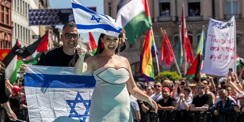 Yuval Raphael représentant Israël marche sur le tapis turquoise à Bâle avec des drapeaux palestiniens derrière lors de la cérémonie d'ouverture du Concours Eurovision de la chanson 2025 à Bâle le 11 mai 2025.