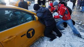Taxi bloqué par la neige à New York. Le nord-est des Etats-Unis était paralysé samedi par une tempête de neige qui a déjà provoqué la mort de neuf personnes dont cinq dans le seul Connecticut, privé 700.000 foyers d'électricité et entraîné l'annulation de