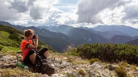 Une femme au sommet d'une montagne après une randonnée.