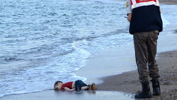 Un officier de police turc devant le corps d'un enfant migrant retrouvé mort sur une plage de Bodrum, au sud de la Turquie, le 2 septembre 2015. Un officier de police turc devant le corps d'un enfant migrant retrouvé mort sur une plage de Bodrum, au sud de la Turquie, le 2 septembre 2015.