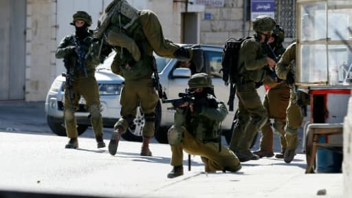 Un soldat israélien porte un de ses collègues blessé après des affrontements avec des Palestiniens dans le camp de réfugiés de Amari, près de Ramallah ke 15 février 2016