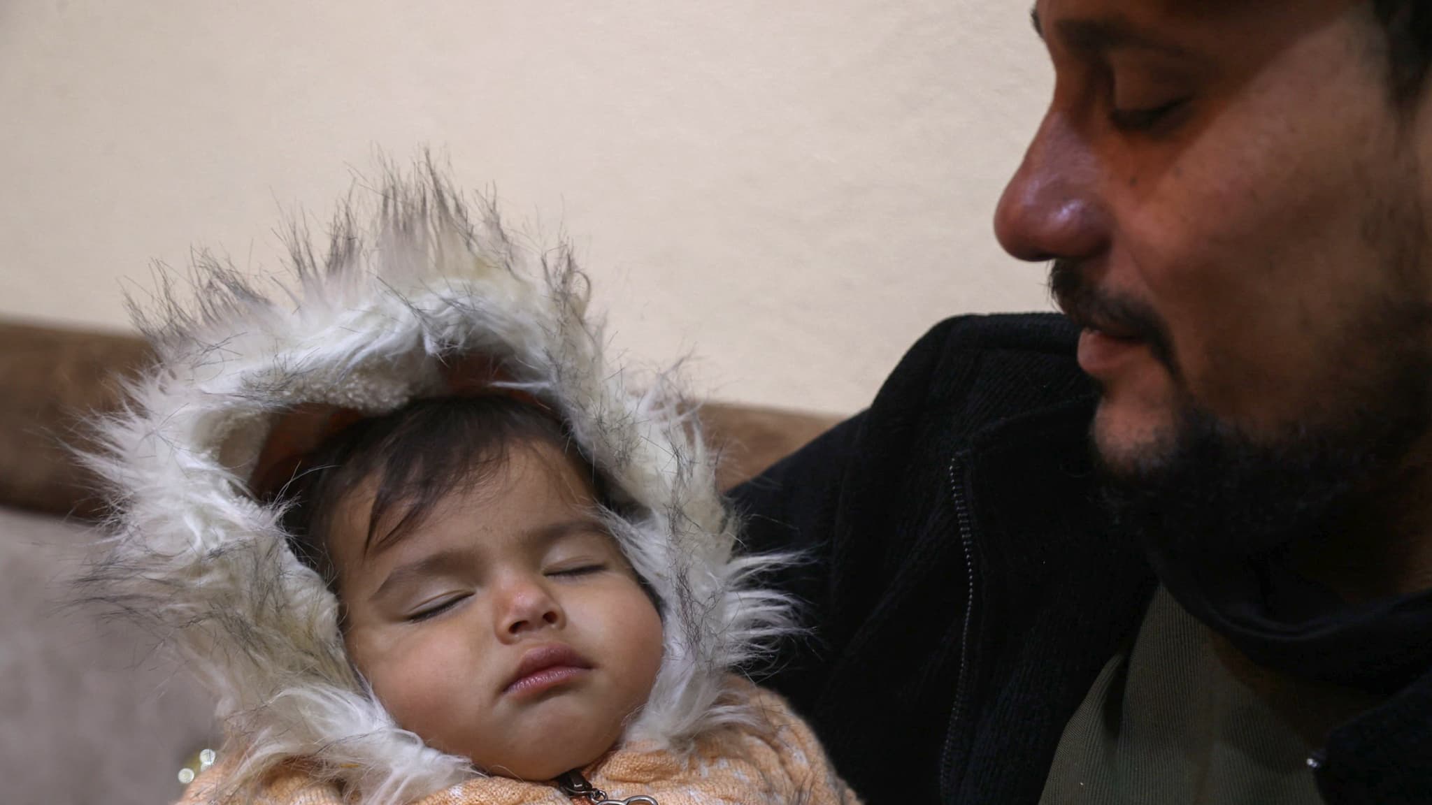 Khalil al-Sawadi avec sa nièce Afraa, sauvée des décombres du tremblement de terre, dans sa maison de la ville de Jandaris, dans le nord-ouest de la province d'Alep, le 2 février 2024.