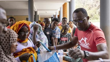 Des habitants de Mayotte font la queue pour recevoir de la nourriture et de l'eau lors d'une distribution à Mtsahara, le 25 décembre 2024.