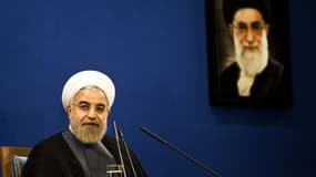 Le Président iranien Hassan Rohani, assis devant un portrait du guide suprême Ali Khamenei lors d'une conférence de presse à Téhéran.