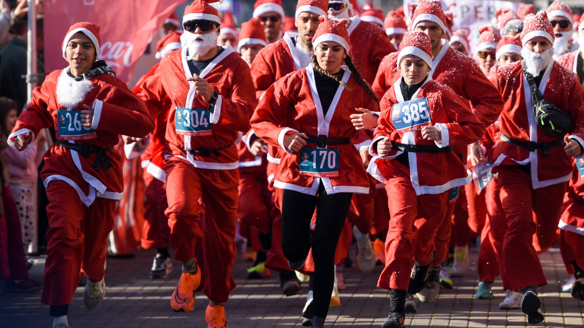 Des participants déguisés en père Noël prennent part à la course annuelle de Noël à Skopje, en Macédoine du Nord, à la veille du jour de Noël, le 24 décembre 2023.