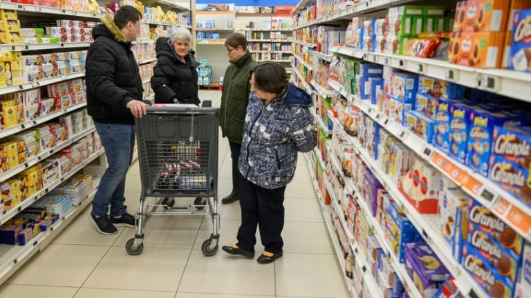 Sylvie Oswald (2eg) fait des courses dans un supermarché avec les personnes qu'elle accueille chez elle, le 25 février 2025 à Raon-l’Etape, dans les Vosges