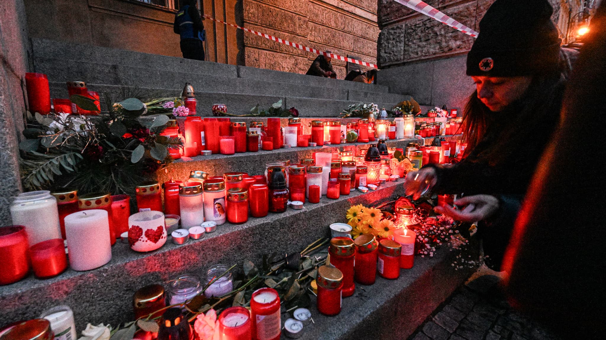 Un témoin allume une bougie alors que des personnes se recueillent devant un mémorial improvisé pour les victimes à l'extérieur de l'Université Charles dans le centre de Prague, le 22 décembre 2023. Un témoin allume une bougie alors que des personnes se recueillent devant un mémorial improvisé pour les victimes à l'extérieur de l'Université Charles dans le centre de Prague, le 22 décembre 2023.