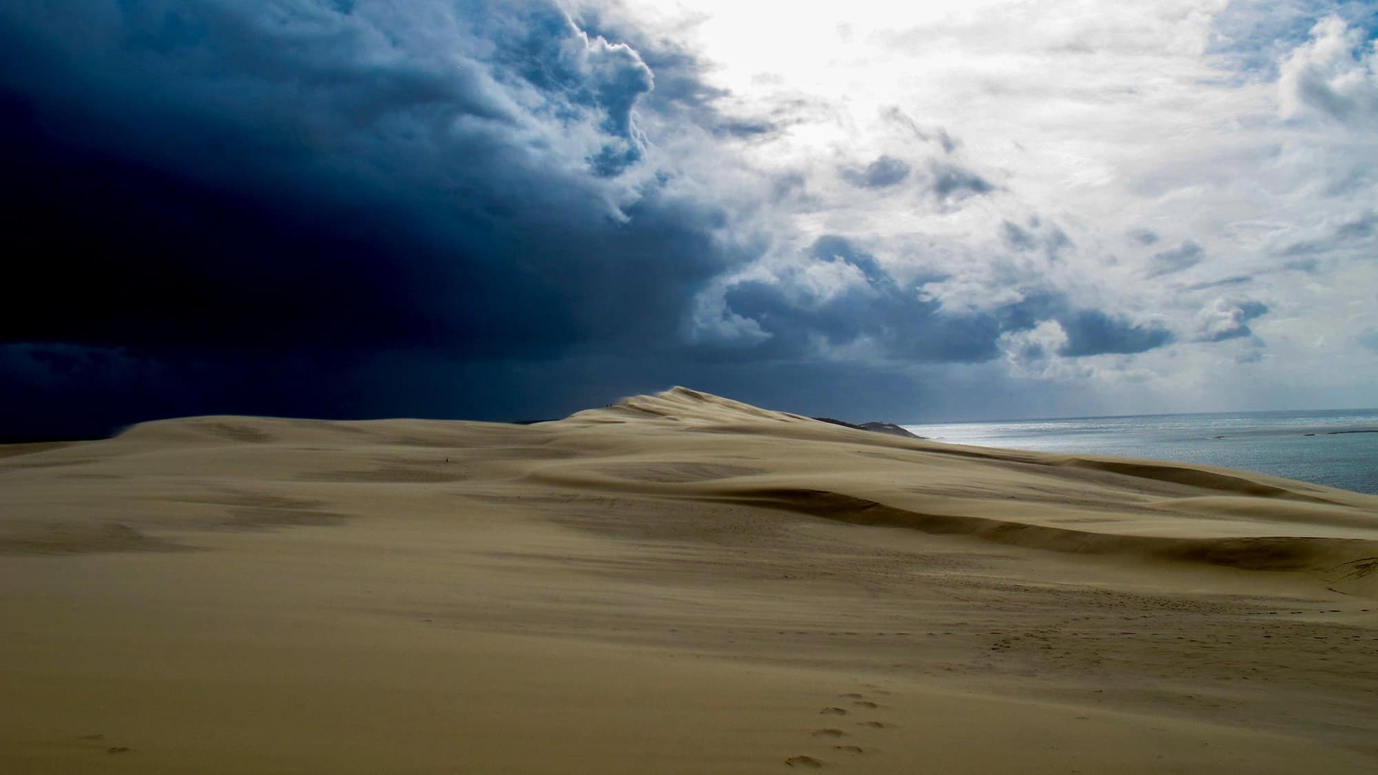 Sous un ciel bas et lourd, le dune se montre en désert romantique. Sous un ciel bas et lourd, le dune se montre en désert romantique.