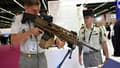 Un militaire français tient un fusil d'assaut du fabriquant belge FN Herstal au salon international de défense Eurosatory à Villepinte, près de Paris, le 13 juin 2022
